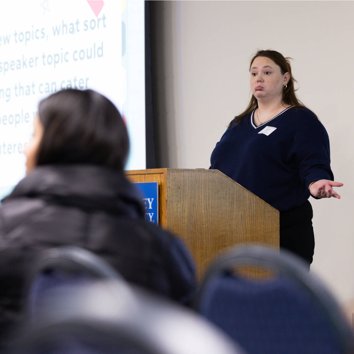 A student presenting in front of a crowd